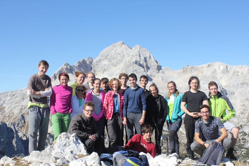 skupinska slika dijakov Vegove na vrhu. V ozadju Triglav