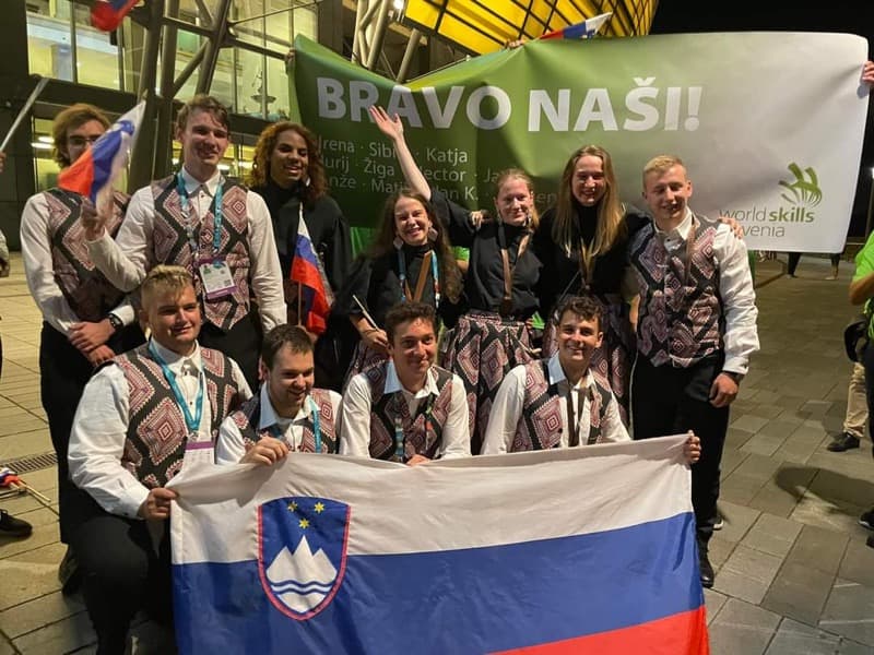 skupinska slika tekmovalcev s slovensko zastavo v ospredju