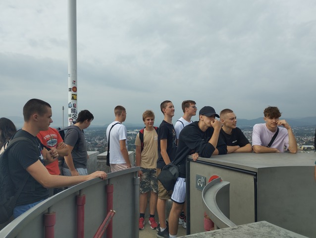 skupina dijakov na vrhu grajskega stolpa s pogledom na ljubljano