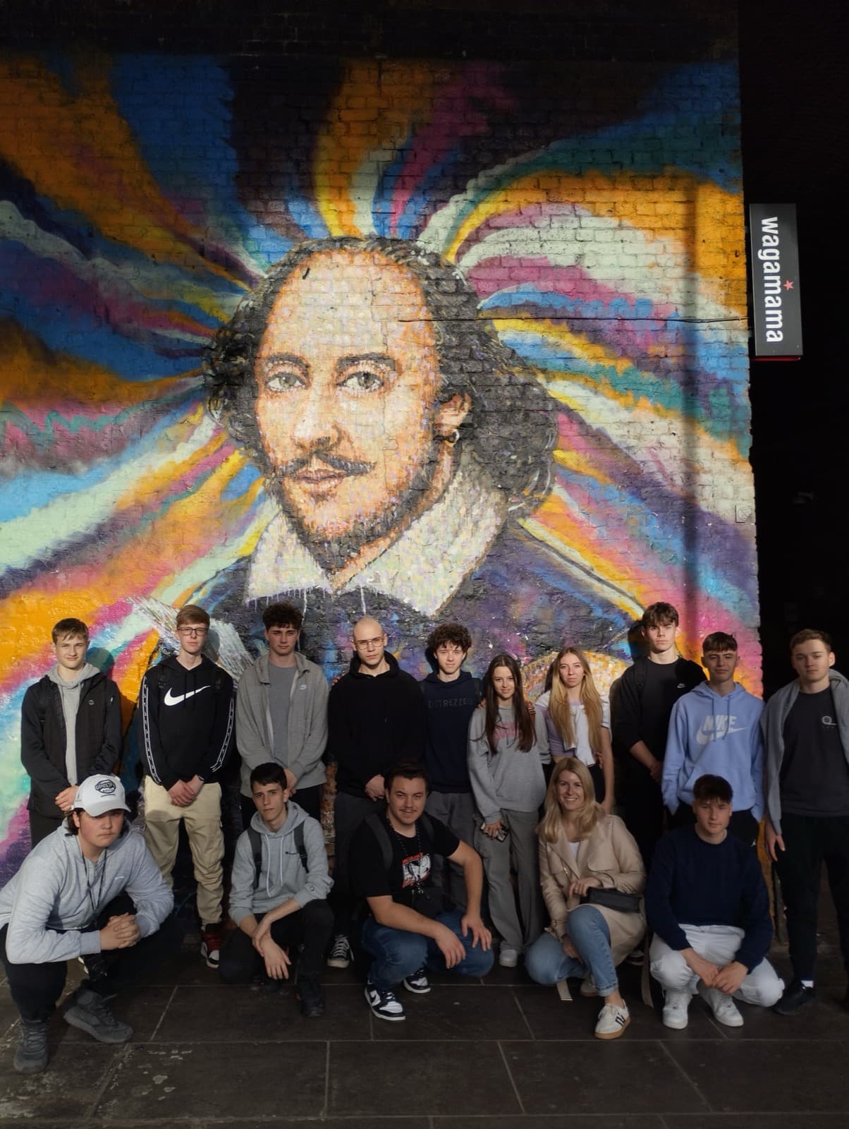 Dijaki in profesorica U. Rozman pred stenskim grafitom W. Shakespeare-a