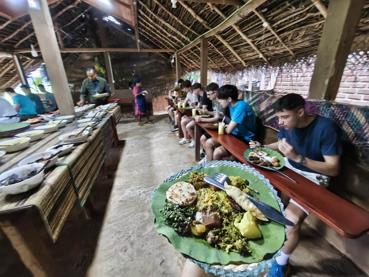 Dijaki jedo tradicionalne jedi z rokami in okušajo lokalne okuse.